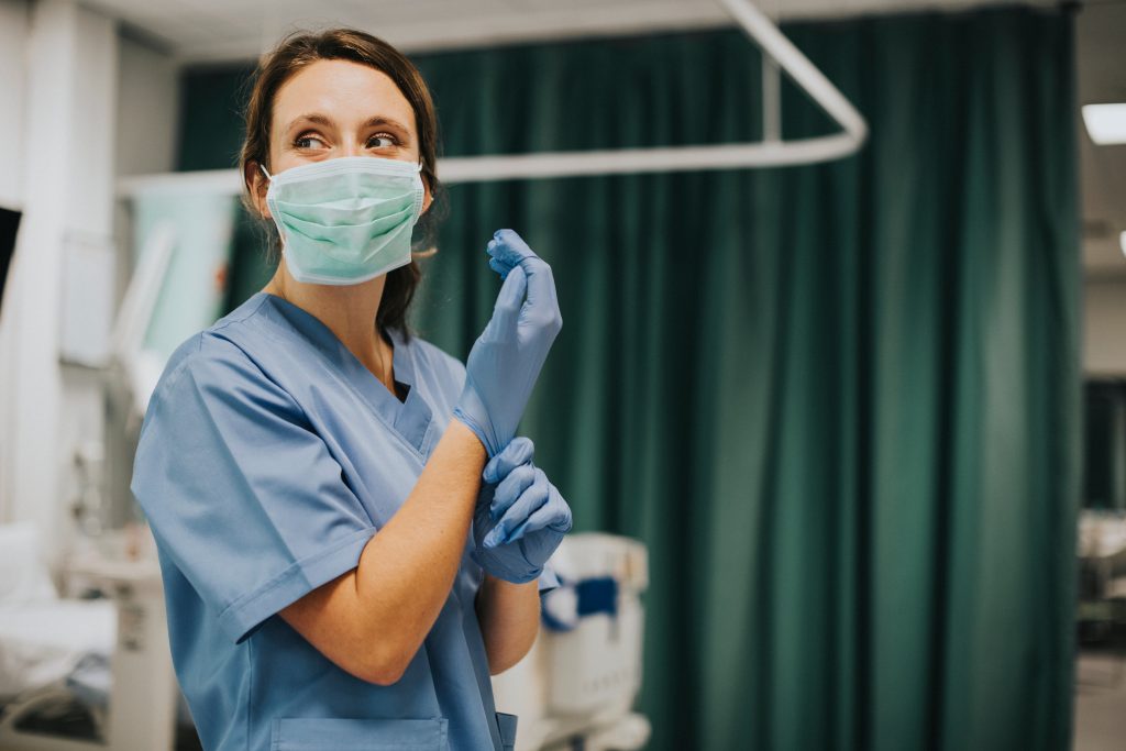 Infirmière enfilant ses gants avant une chirurgie