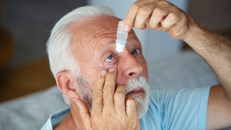 Un homme âgé applique des gouttes pour le glaucome