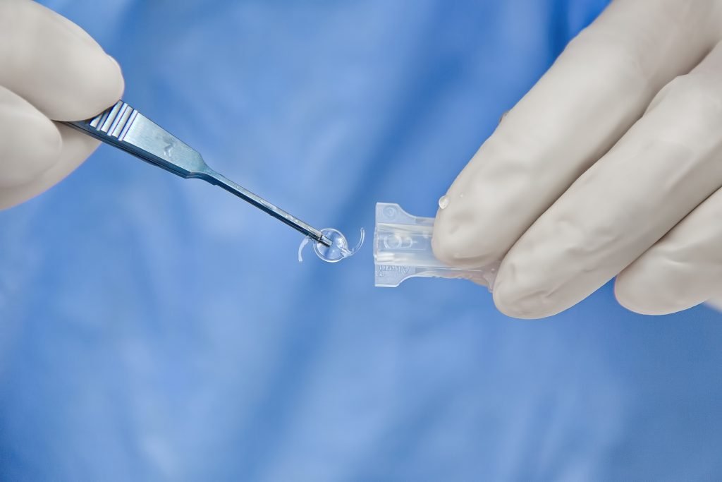 Lentille intraoculaire tenue avec une pince